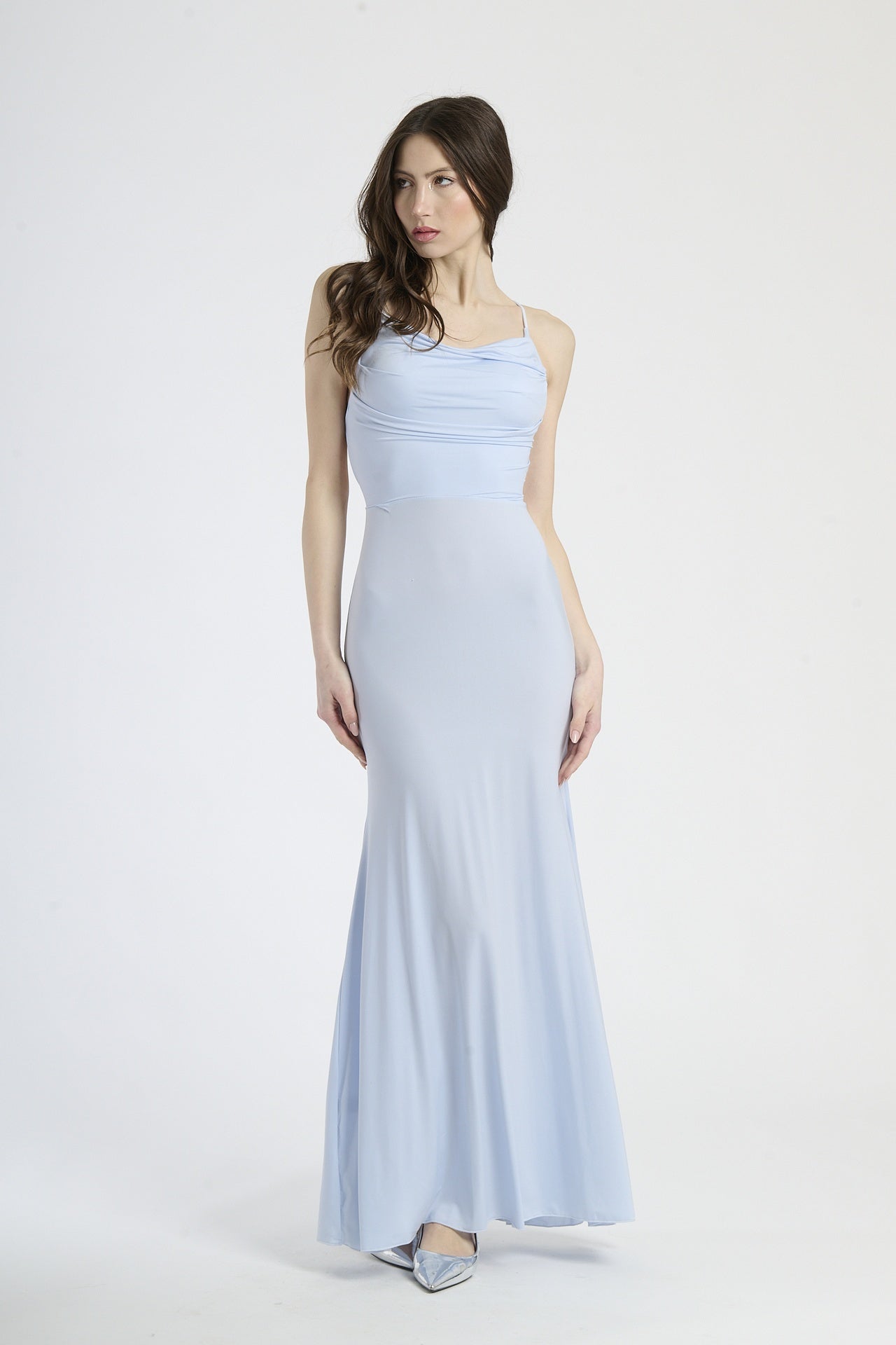 Donna con abito azzurro a spalline sottili, eleganza rinfrescante e fluida.
