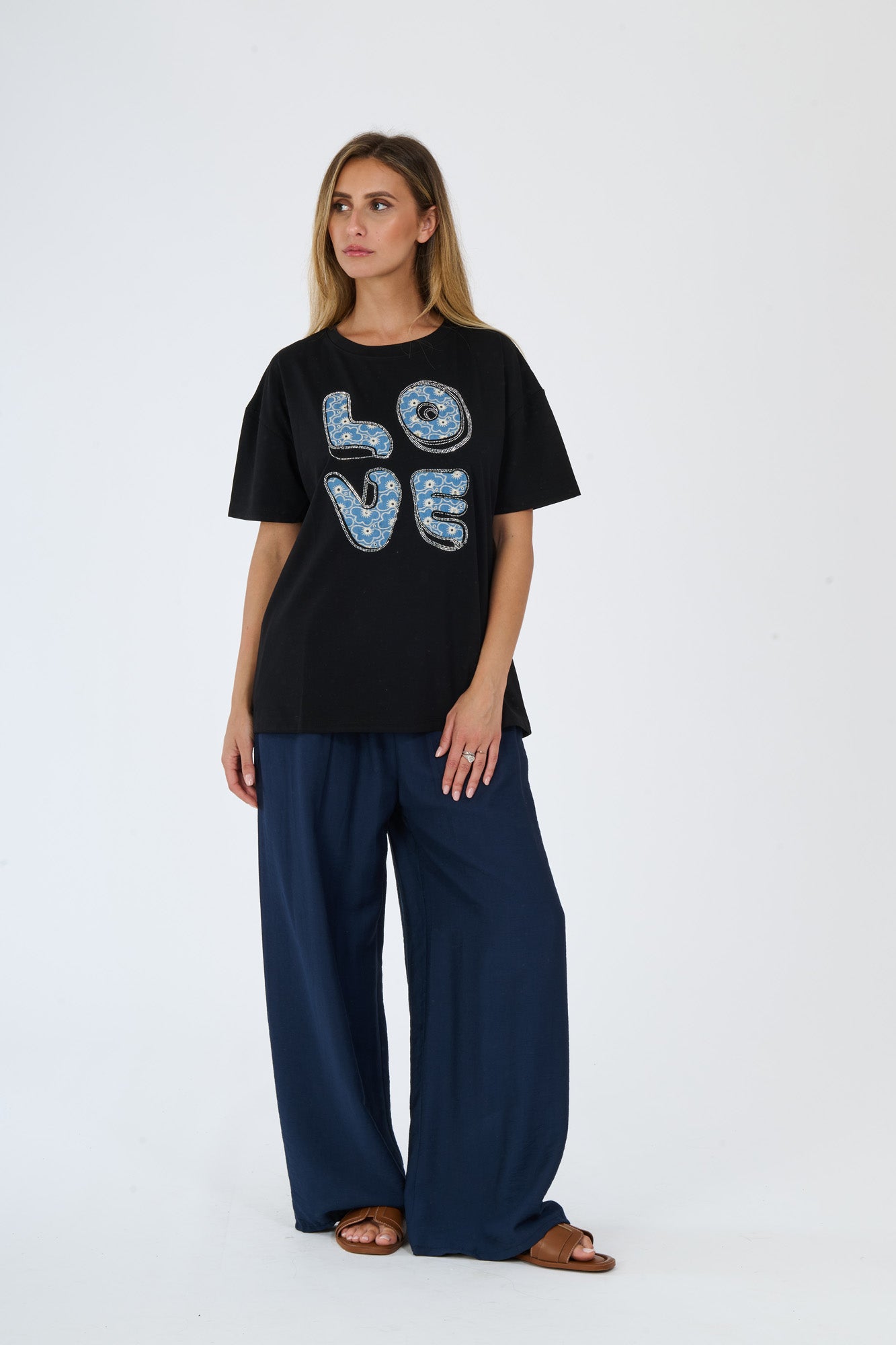 Donna con t-shirt nero e pantaloni larghi scuri
