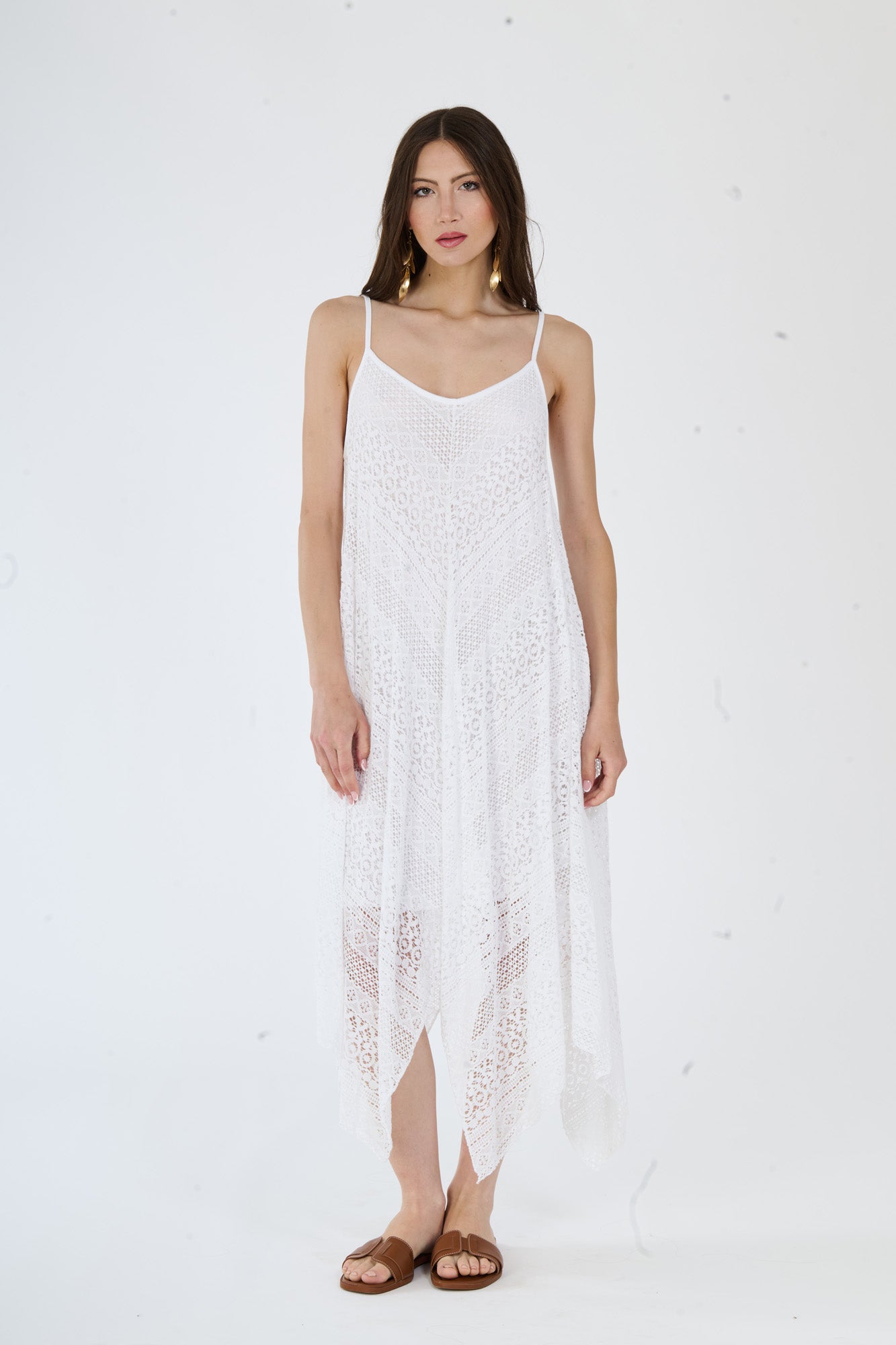 Elegante vestito bianco in maglia a fori, con un taglio asimmetrico che conferisce stile e modernità.