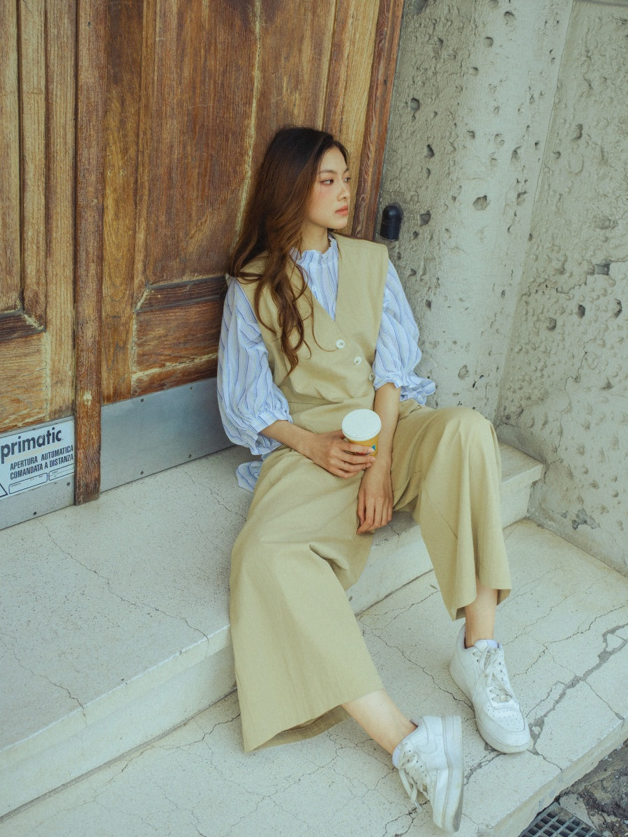 Combinazione beige: gilet senza maniche, camicia a righe e pantaloni, perfetto per l’estate.