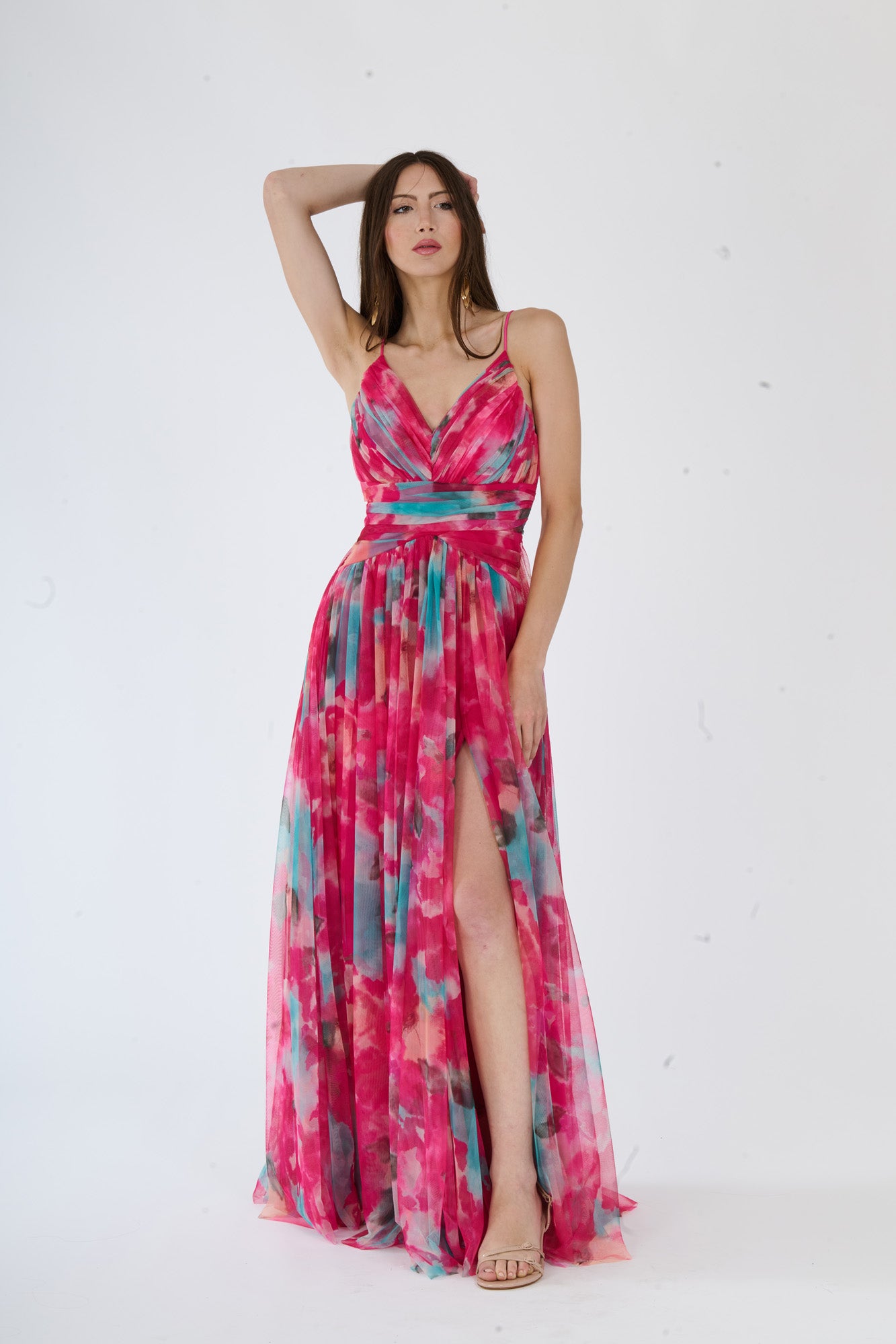 Abito elegante fuxia con decolleté a V, fascia vita e stampa multicolore, indossato da una ragazza