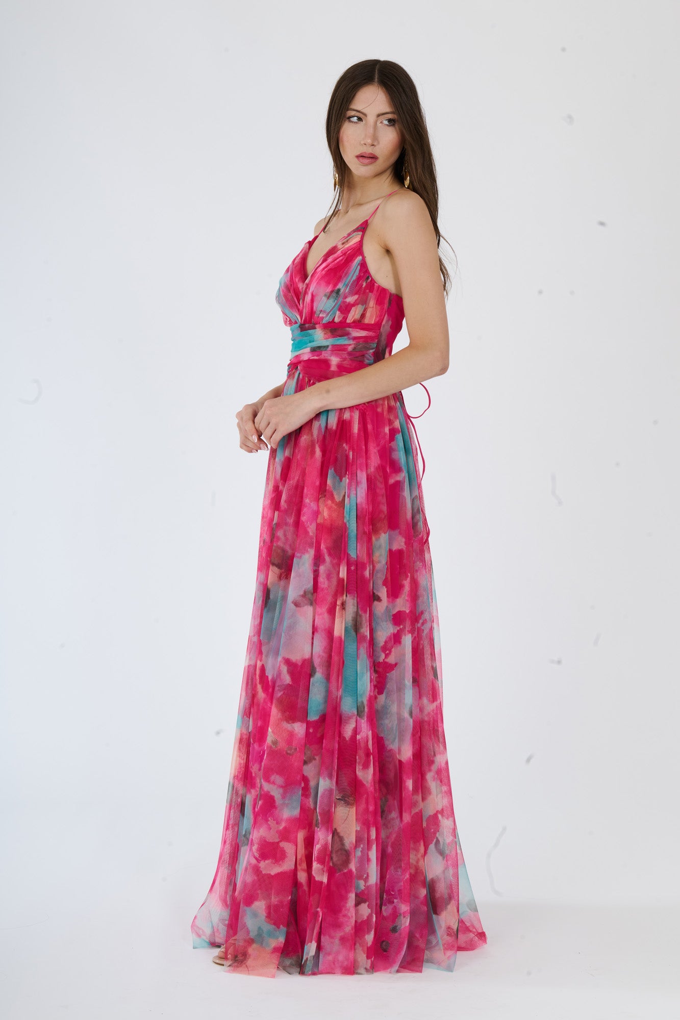 Modella in abito maxi fuxia con stampa floreale, spalline sottili e apertura laterale