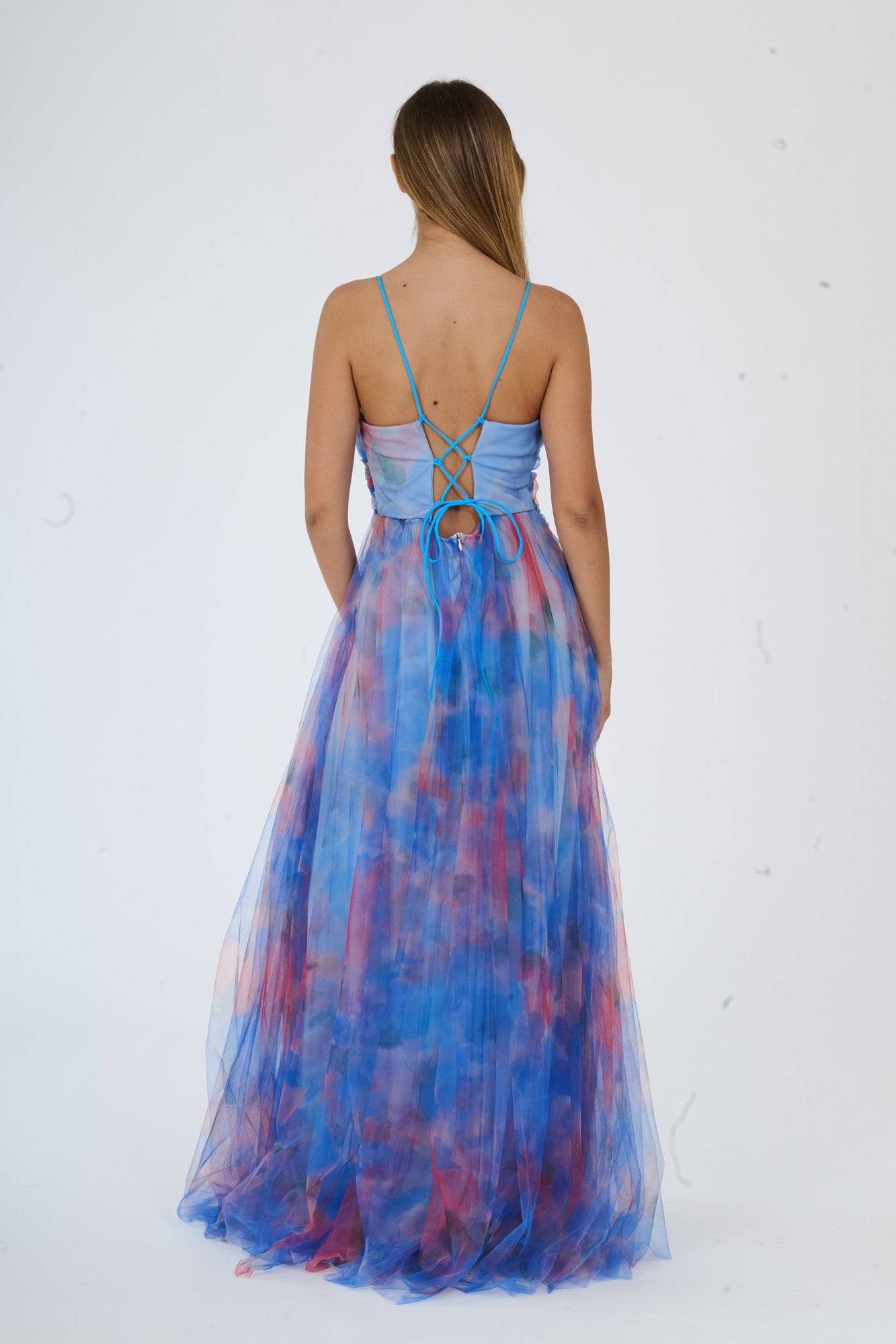 Modella in abito maxi azzuro con stampa floreale, spalline sottili e apertura laterale