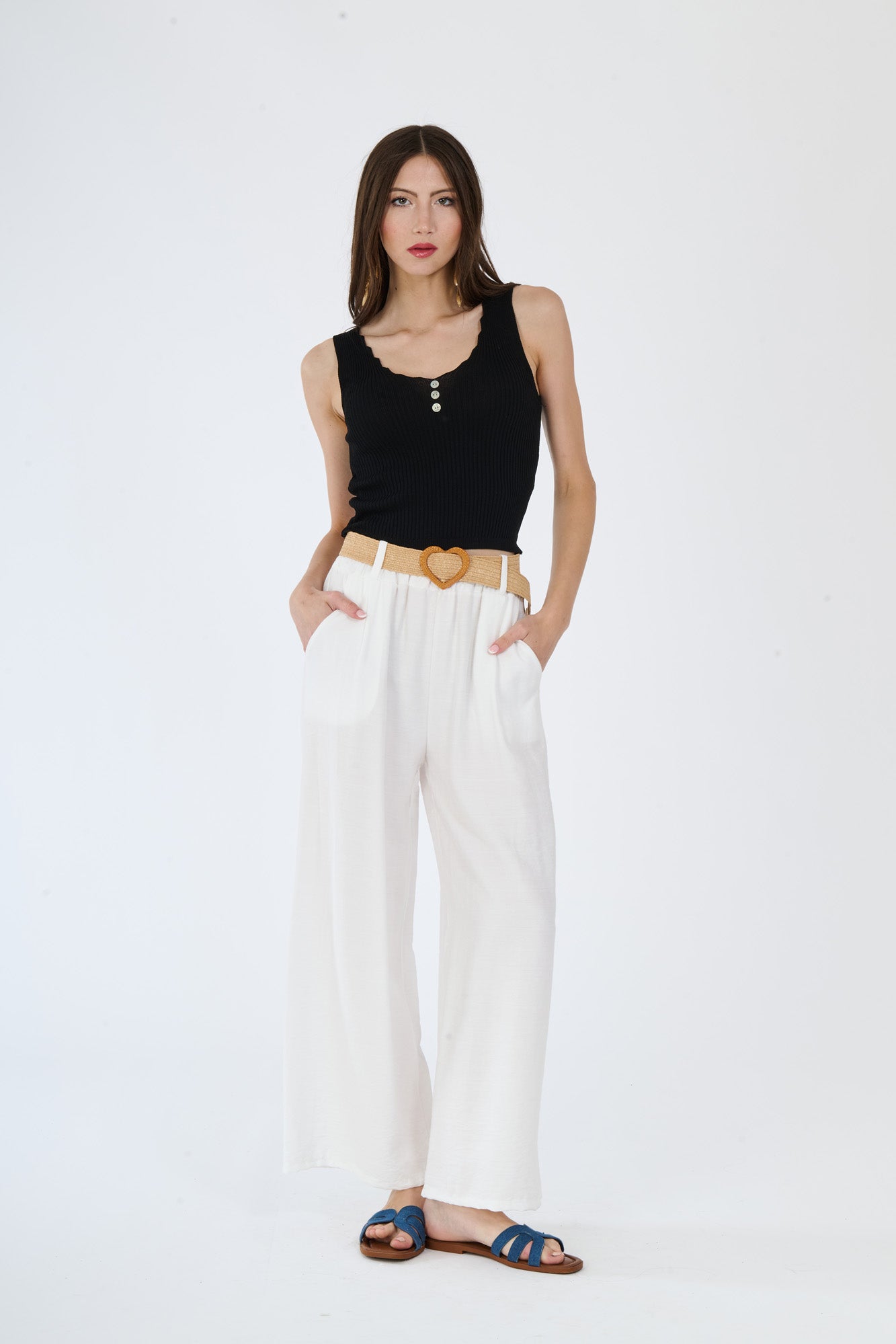 Outfit di top nero e pantaloni larghi bianchi, perfetto per occasioni in cui si vuole esprimere eleganza ed impatto visivo.
