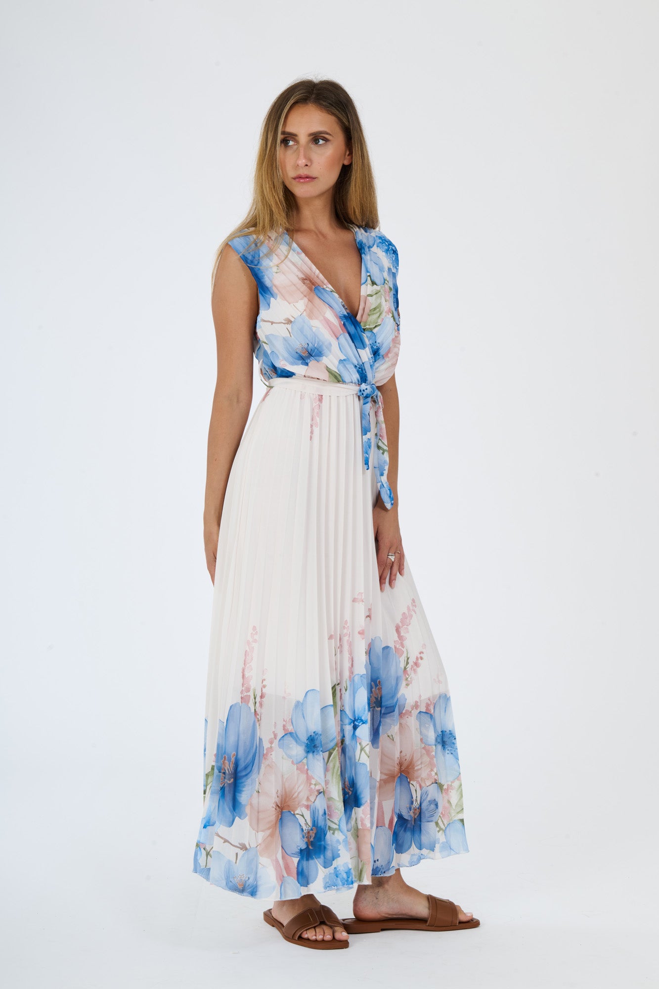Modella in abito maxi Azzuro con motivi floreali, scollatura a V, maniche nude e fascia tie - waist
