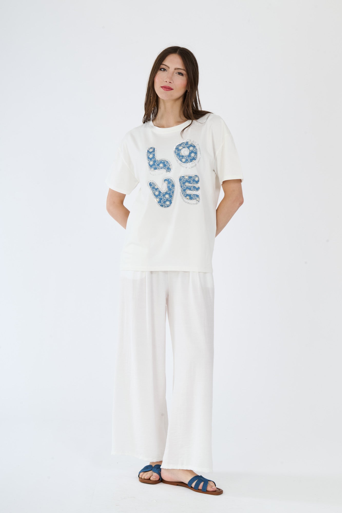 Modella in t-shirt bianco e pantaloni scuri, abbinamento casual