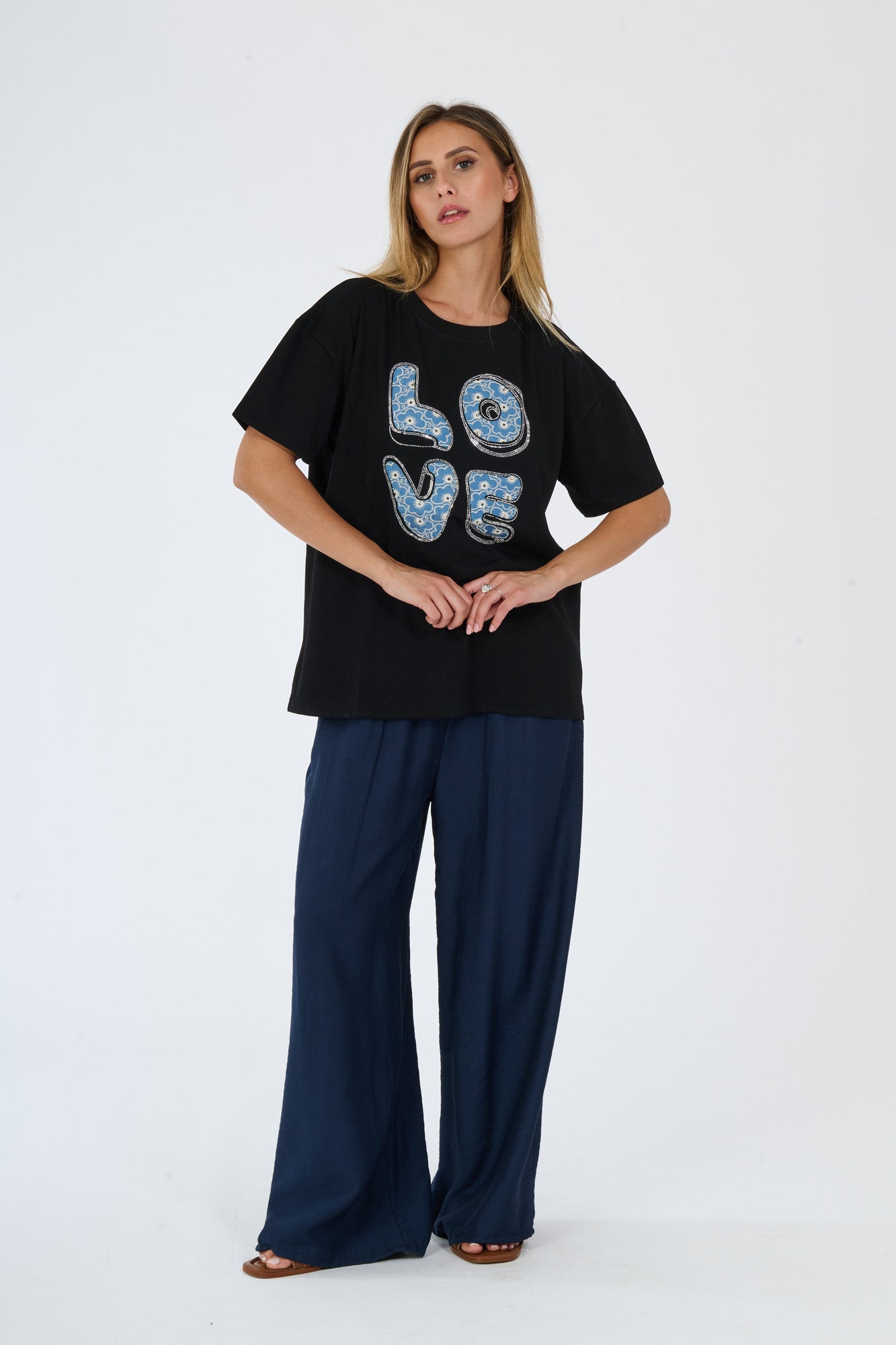 Modella in t-shirt nero e pantaloni scuri, abbinamento casual