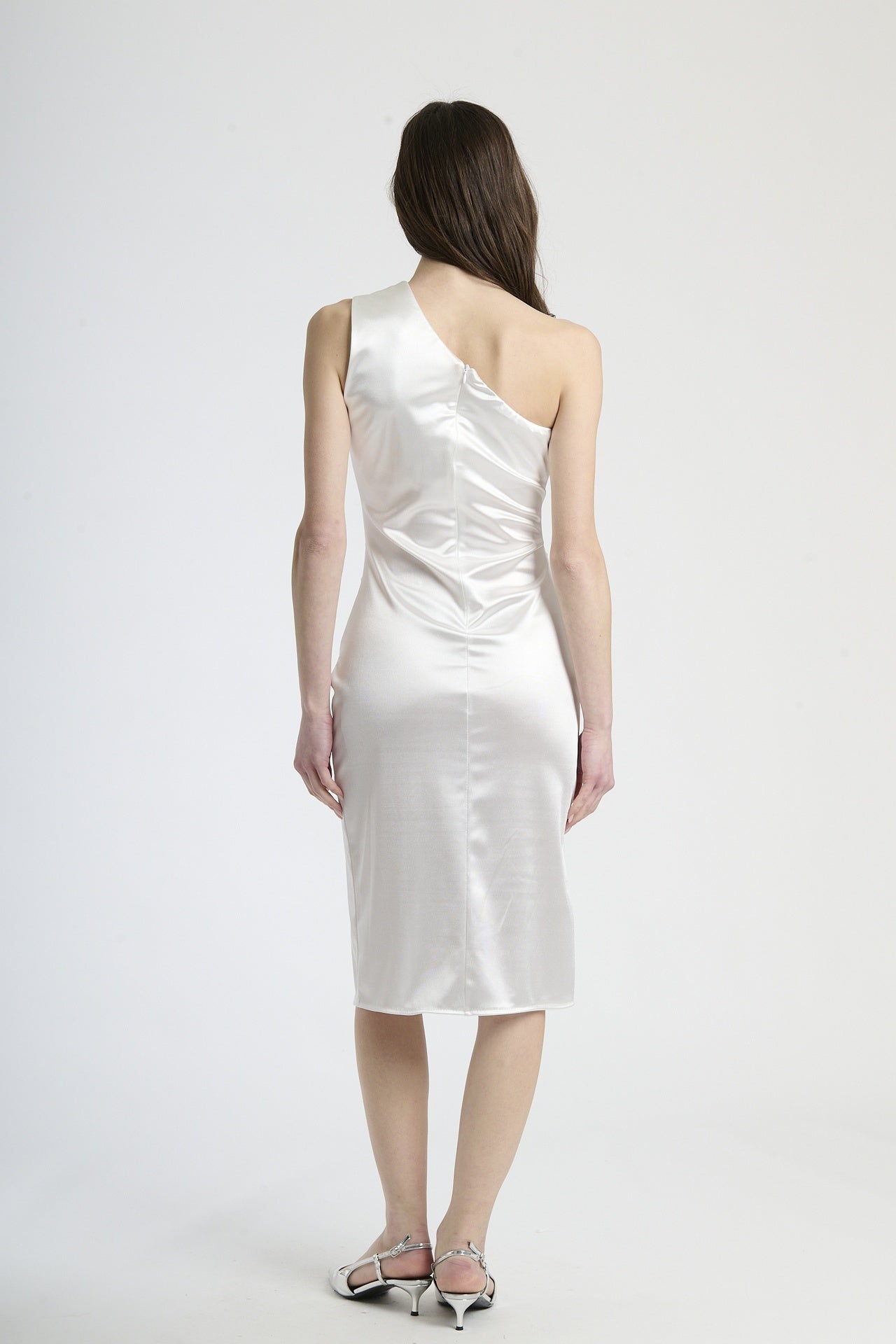 Modella indossa abito bianco con plissé, stile raffinato per eventi esclusivi.