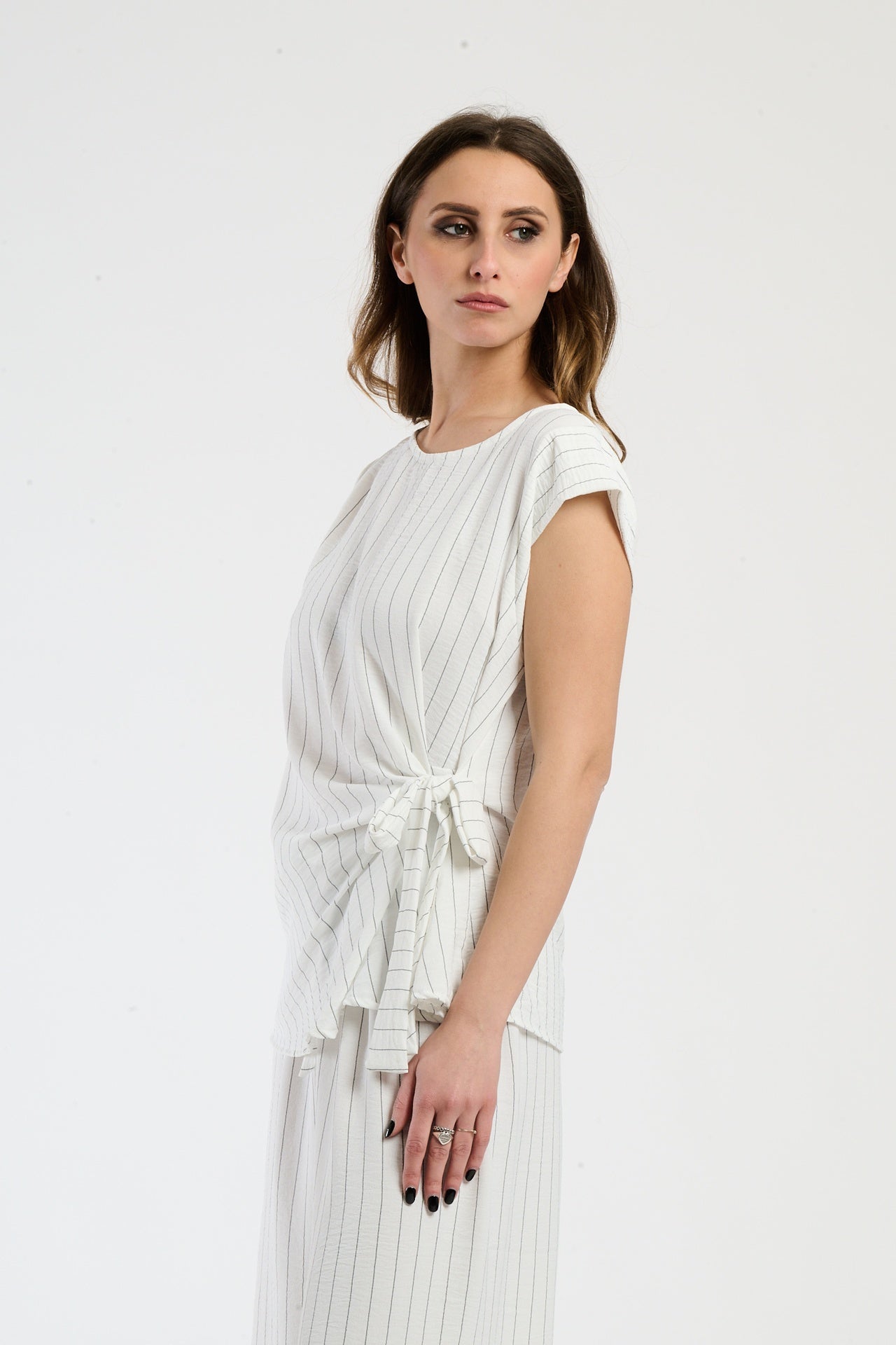Set bianco con top a maglia e pantaloni ampi, freschezza e comfort.
