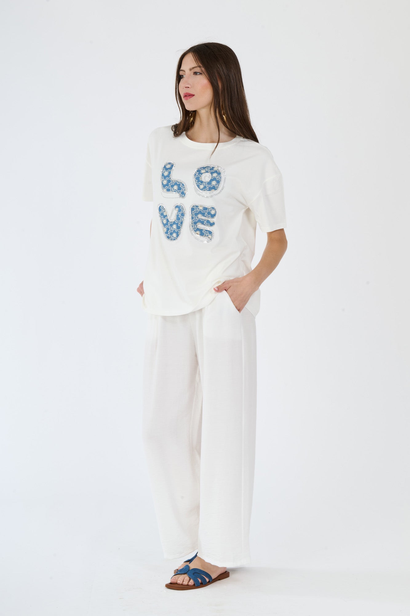 T-shirt bianco e pantaloni scuri larghi indossati da una donna