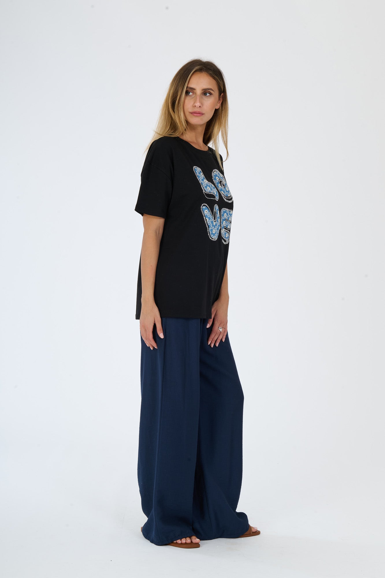 T-shirt nero e pantaloni scuri larghi indossati da una donna