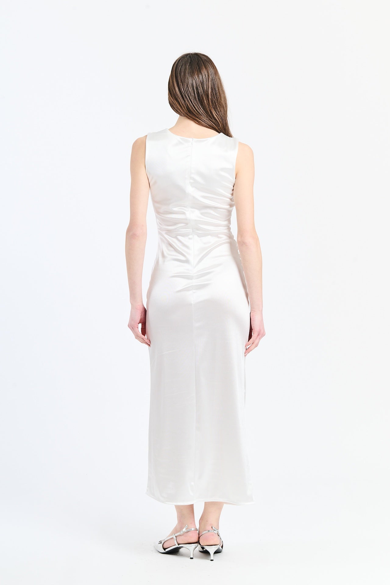 Vestito bianco luminoso con drappeggi sul busto e tessuto lucido