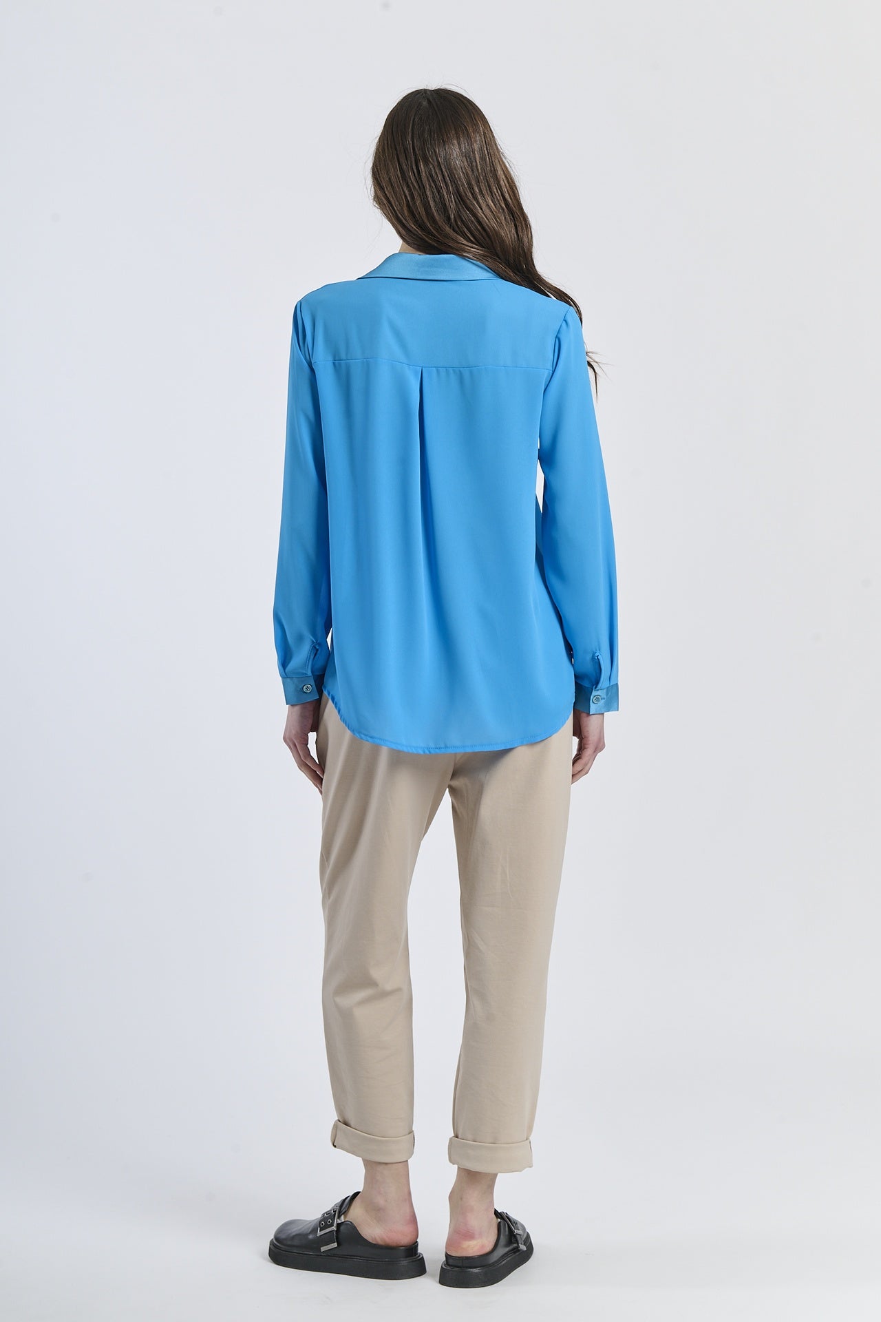 Outfit con camicia turchese e pantaloni neri, contrasto acido