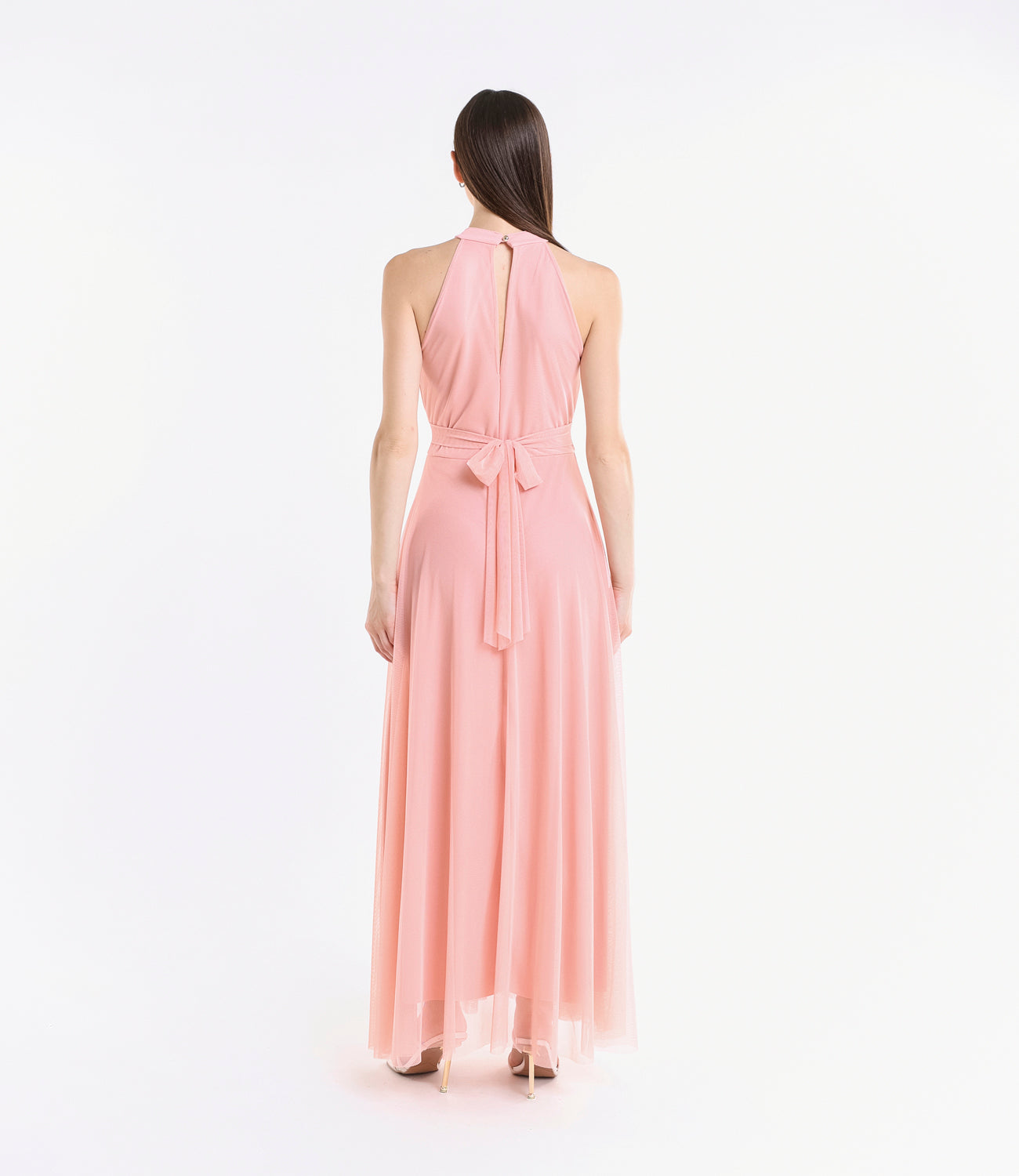 Abito rosa pastello, collo alto a nodo, pianta verde artificiale nel background
