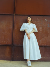 Vestito bianco corto con maniche voluminose, design moderno per uno stile audace.