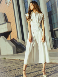 Abito bianco classico con colletto, taglio avvolgente, ideale per esprimere eleganza semplice.