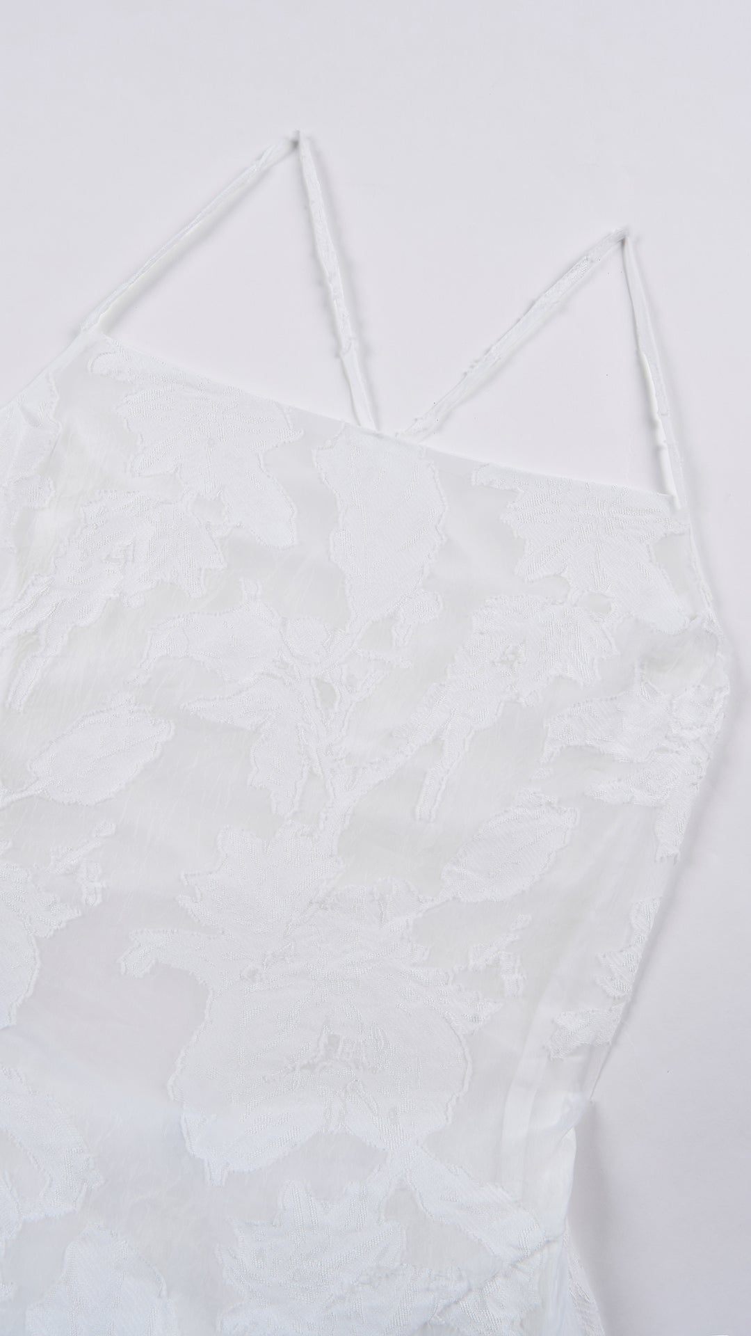 Abito corto elegante a spalline sottili con scollo a fascia, tessuto jacquard floreale e dettaglio a croce sul retro