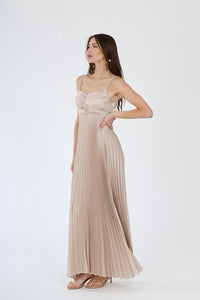 Abito beige in tessuto opaco con plissé, spalline sottili e dettagli ruched, per uno stile discreto e raffinato.