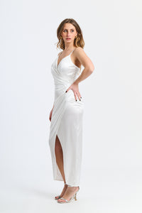 Abito bianco dritto, apertura leggera, spalline sottili, atmosfera raffinata