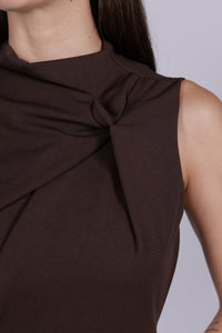 Abito da donna marrone, senza maniche, midi, nodo sul petto, estetica elegante e calda.