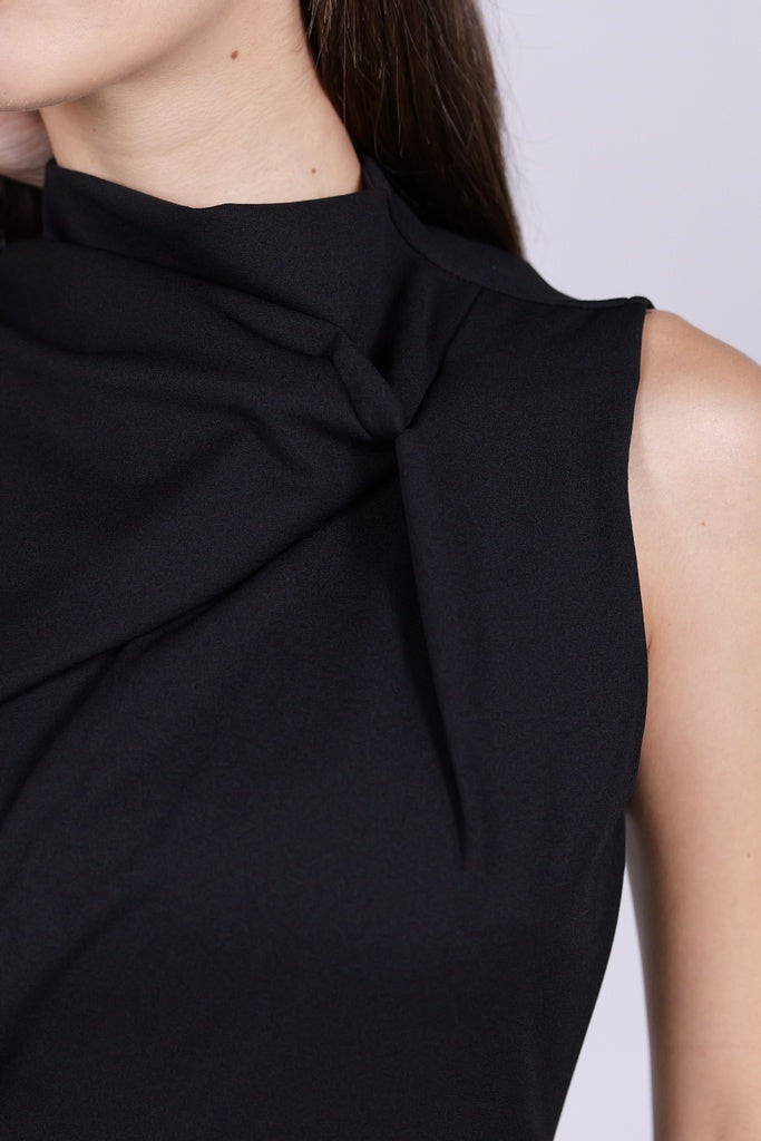 Abito da donna nero, senza maniche, midi, nodo sul petto, estetica elegante e seducente.