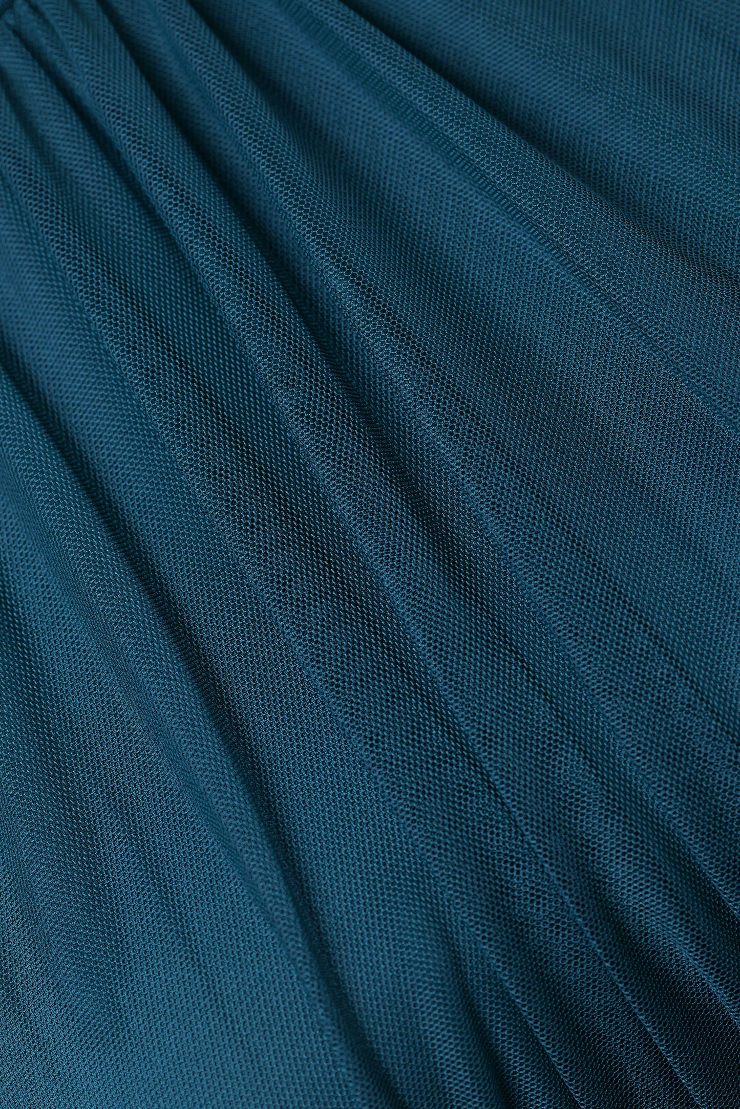 Abito da donna ottanio, collo alto a imbarcatura, gonna lunga, foulard in tulle, estetica elegante e contemporanea.