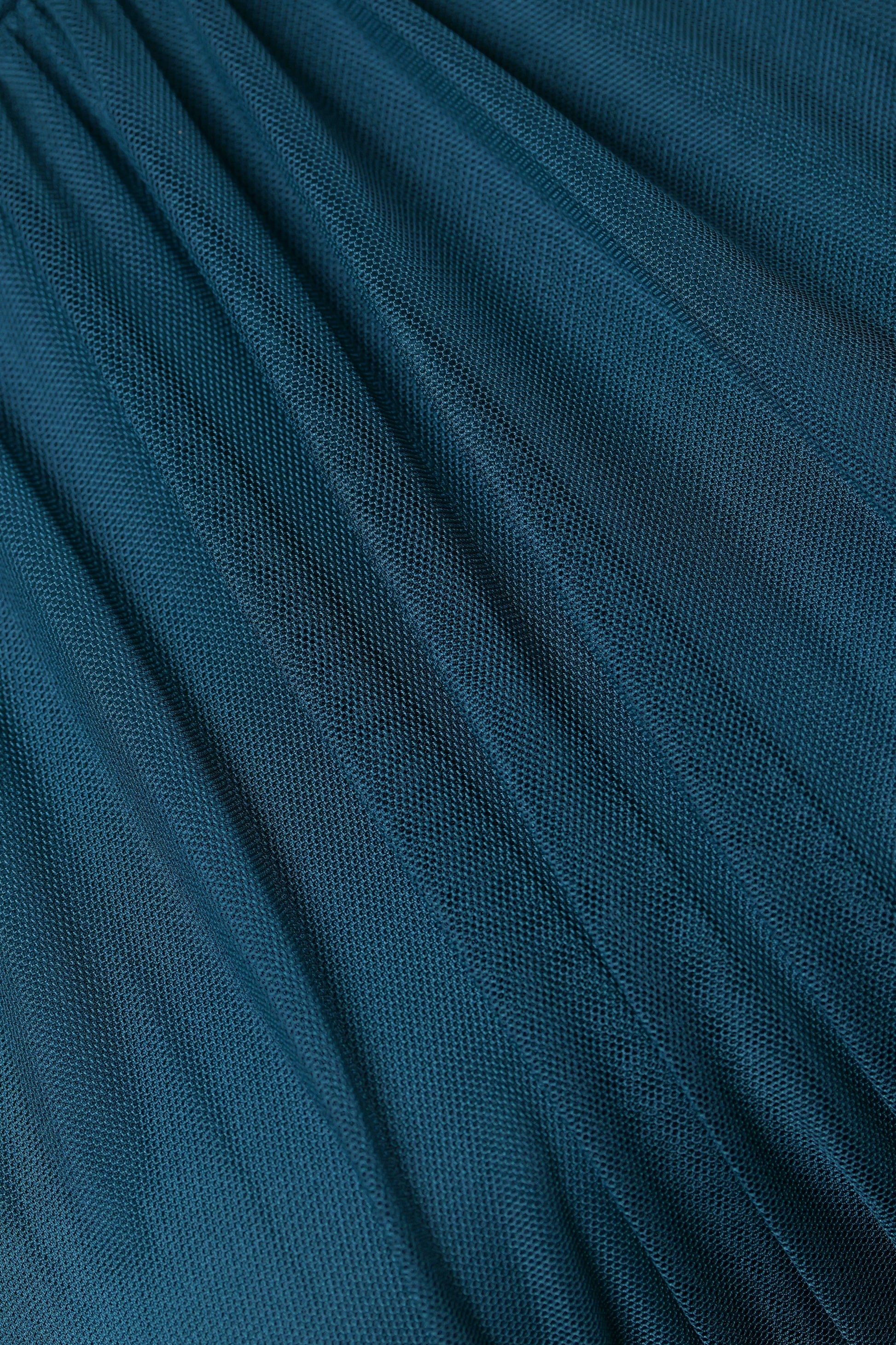 Abito da donna ottanio, collo alto a imbarcatura, gonna lunga, foulard in tulle, estetica elegante e contemporanea.