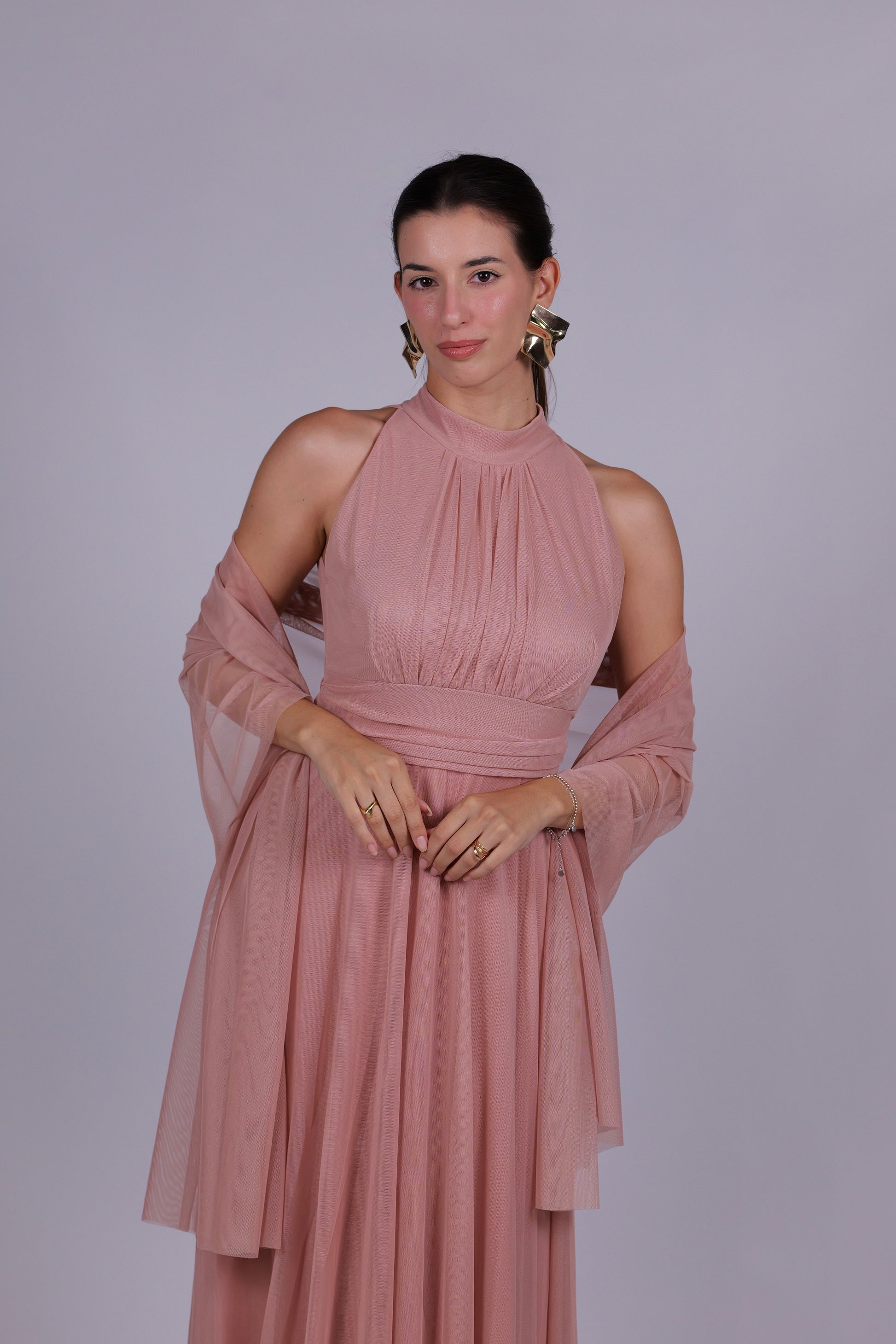 Abito da donna rosa, collo alto a imbarcatura, gonna lunga, foulard in tulle, estetica elegante e delicata.