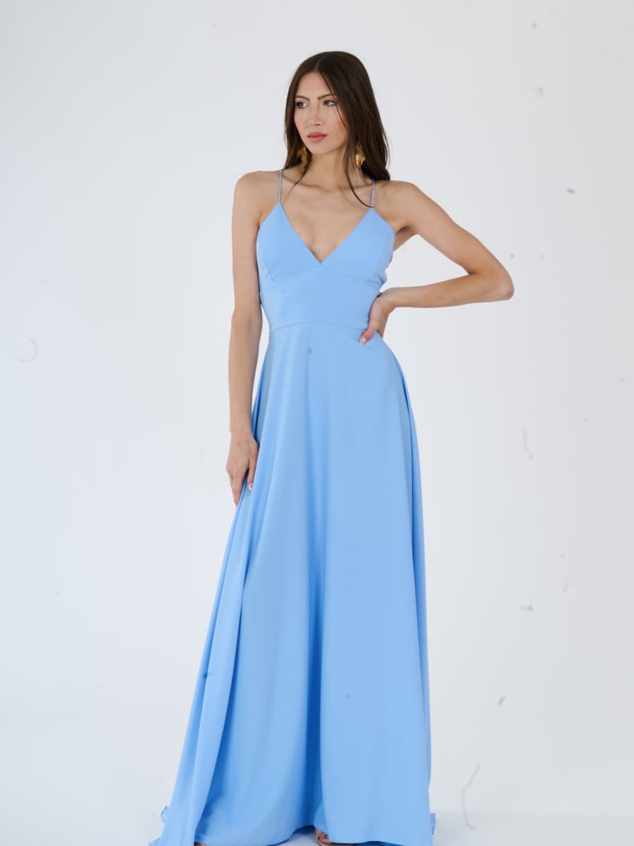 Abito da sera azzurro fluido con silhouette allungata e spalline nude.