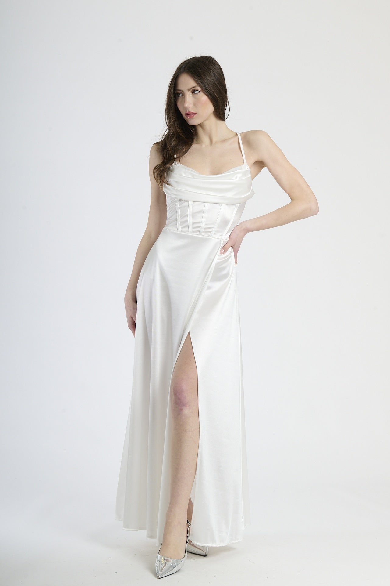 Abito lungo bianco in raso, con spalline sottili, colletto drappato e spalanca laterale.