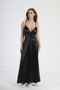 Abito lungo nero in raso, con spalline sottili, scollatura a V profonda e silhouette fluida.