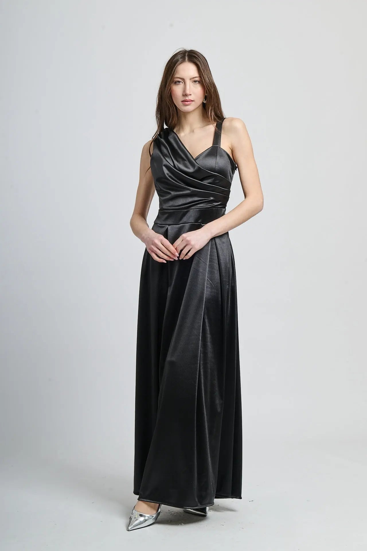 Abito lungo nero in seta, spalliera asimmetrica e fascia vita definita.