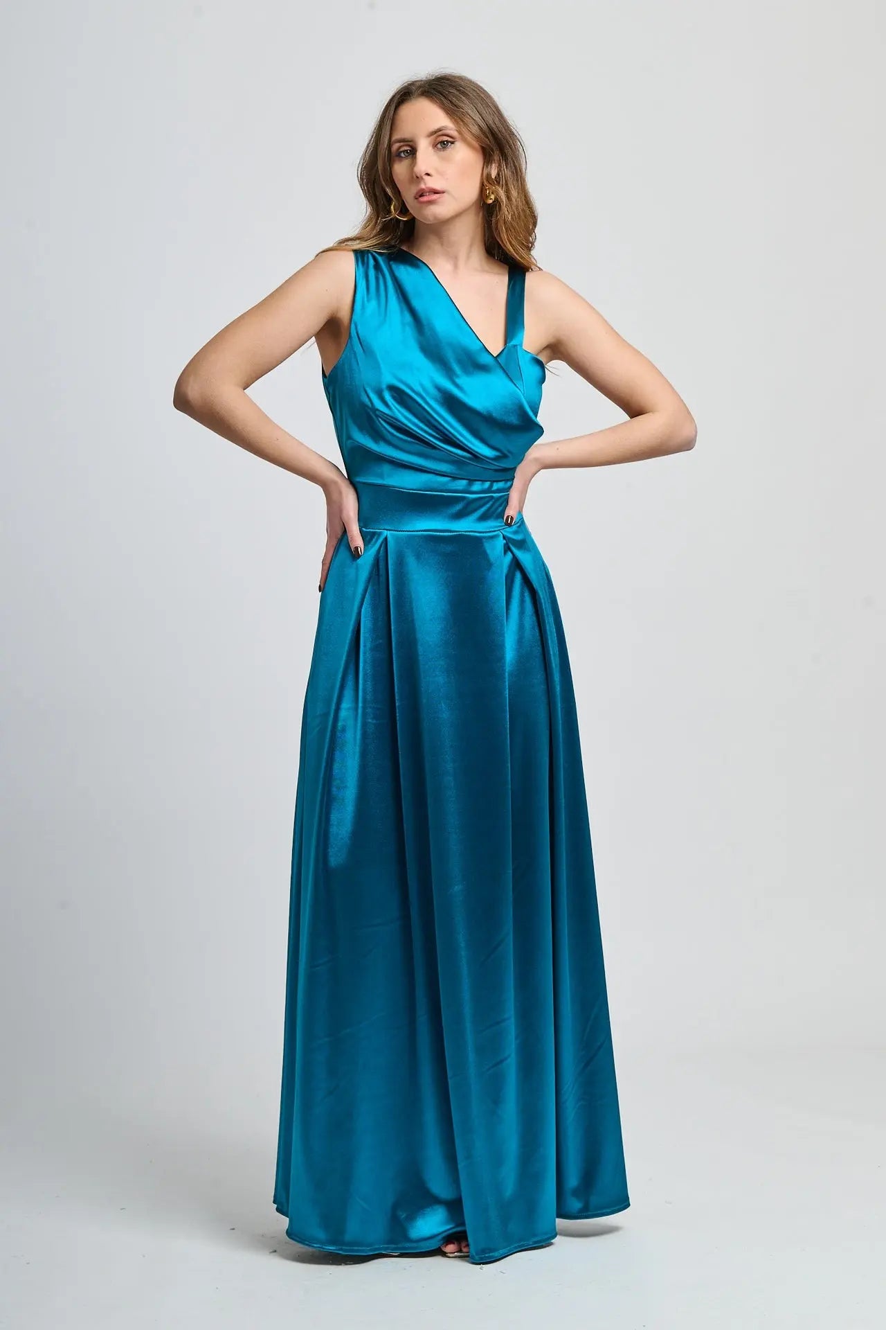 Abito lungo ottanio in seta, spalliera asimmetrica e fascia vita definita.