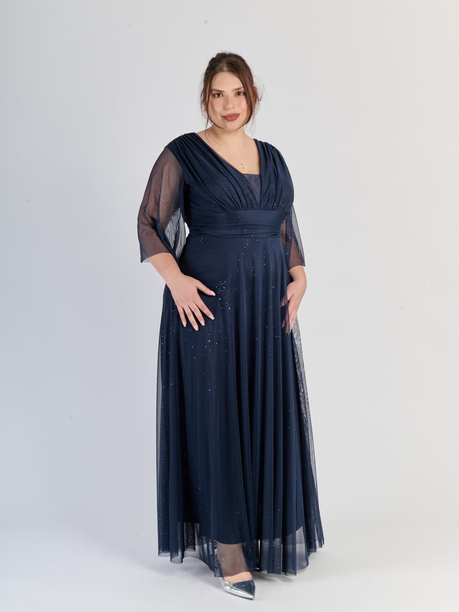 Abito navy da cerimonia, flusso e con maniche traslucide, incarna l’eleganza blu scuro.