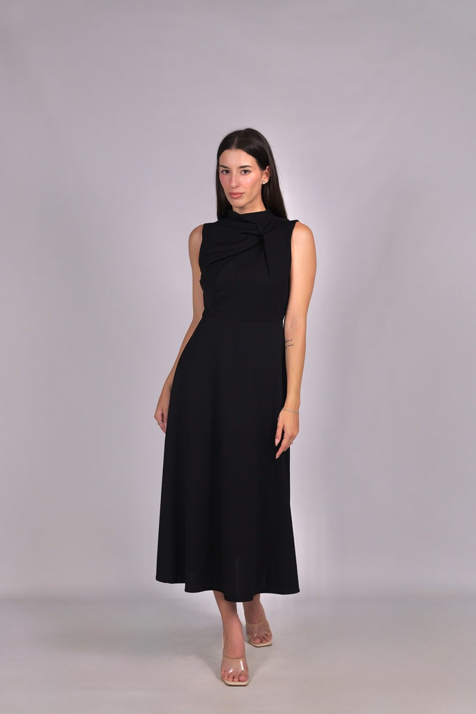 Abito nero da donna, senza maniche, lunghezza midi, dettaglio nodo sul petto, stile elegante e misterioso.