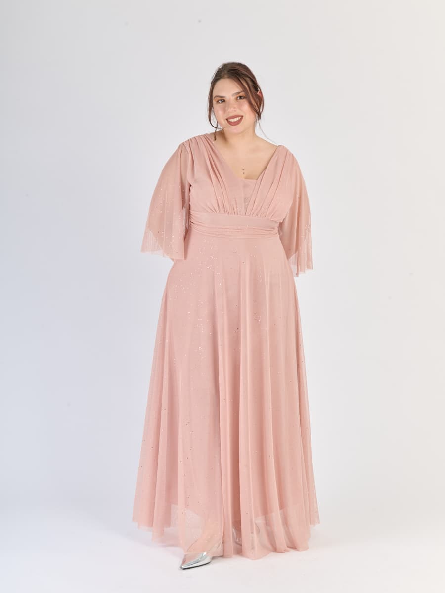 Abito rosa antico da cerimonia, flusso e con maniche traslucide, evoca il fascino del passato.