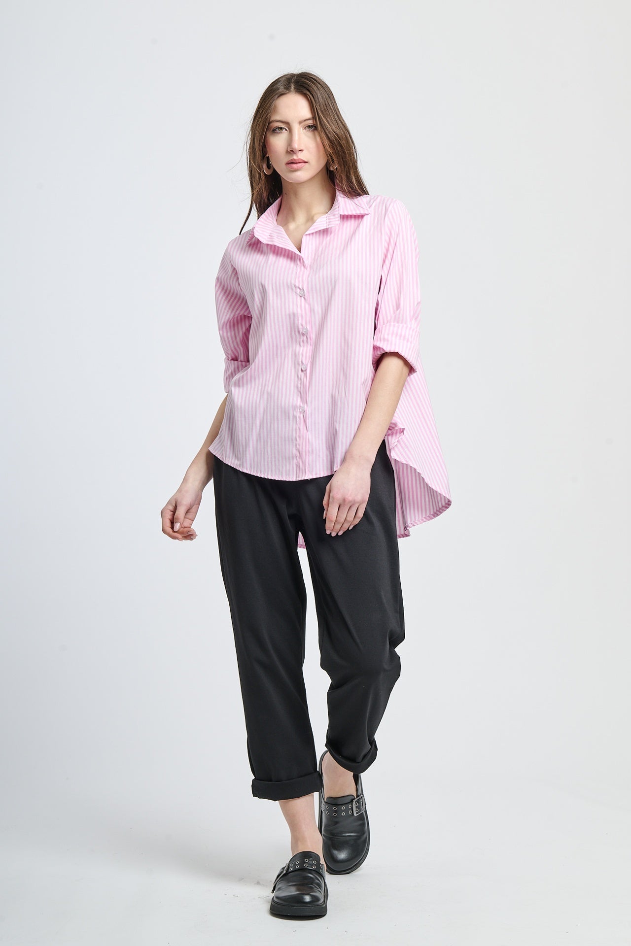 Camicia a righe rosa pastello, abbinata a pantaloni neri, stile delicato