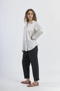 Camicia bianca fluida e luminosa, maniche lunghe e design minimalista.