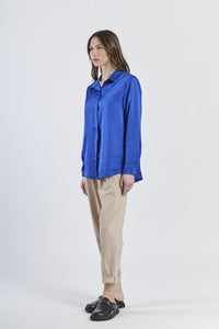 Camicia bluette fluida e rassicurante, maniche lunghe e design delicato.