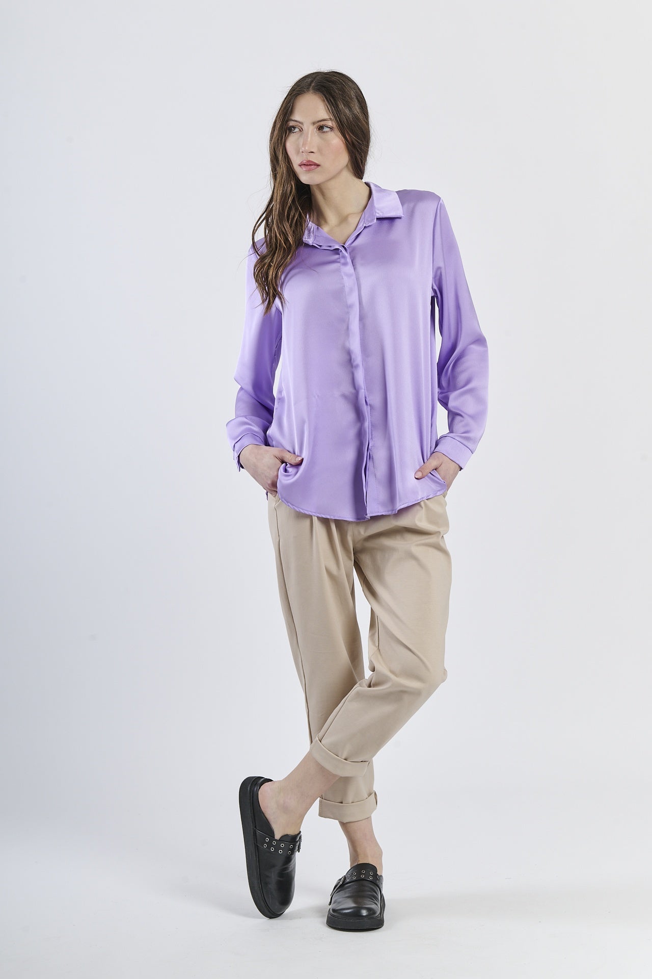 Camicia lilla in seta con colletto, abbinata a pantaloni beige.