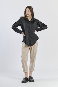 Camicia nera in tessuto satinato, simbolo di eleganza atemporale.