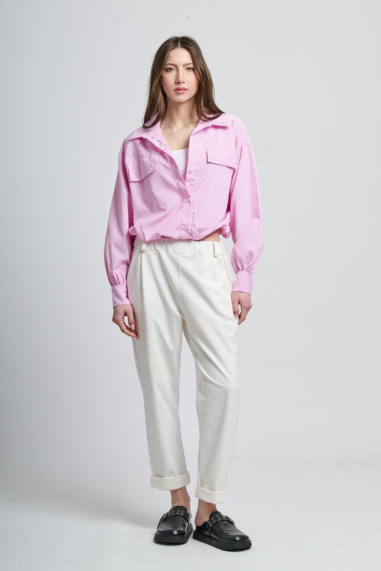 Camicia oversize rosa e pantaloni bianchi per uno stile cool