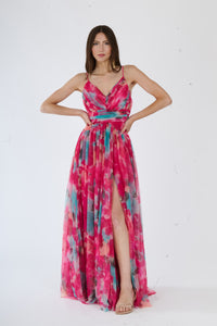Donna con abito lungo fuxia a spalline sottili, stampa sfumata e slit laterale