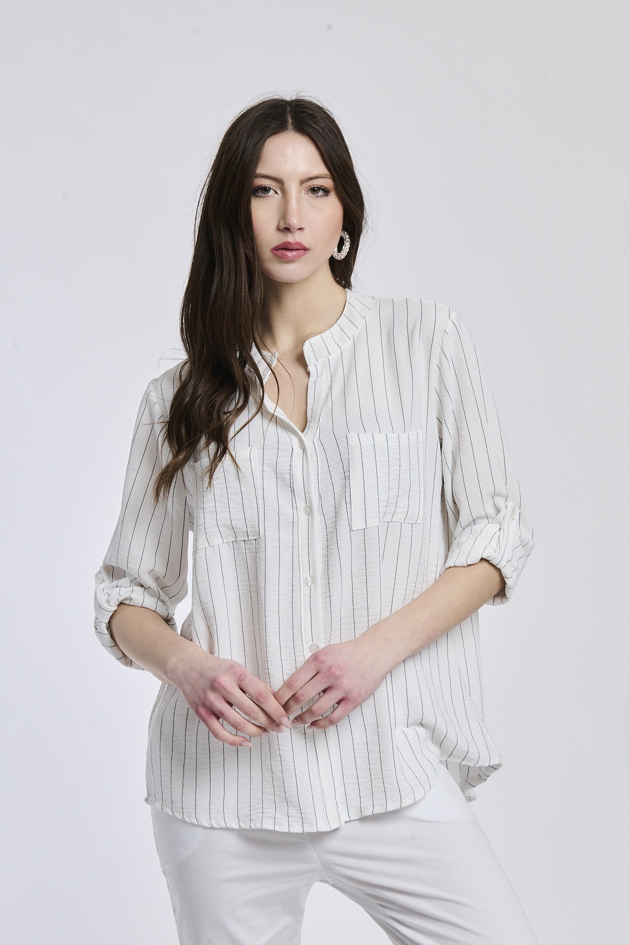 Donna con camicia bianca a bottoni, collo a V, maniche 3/4, stile pulito e elegante