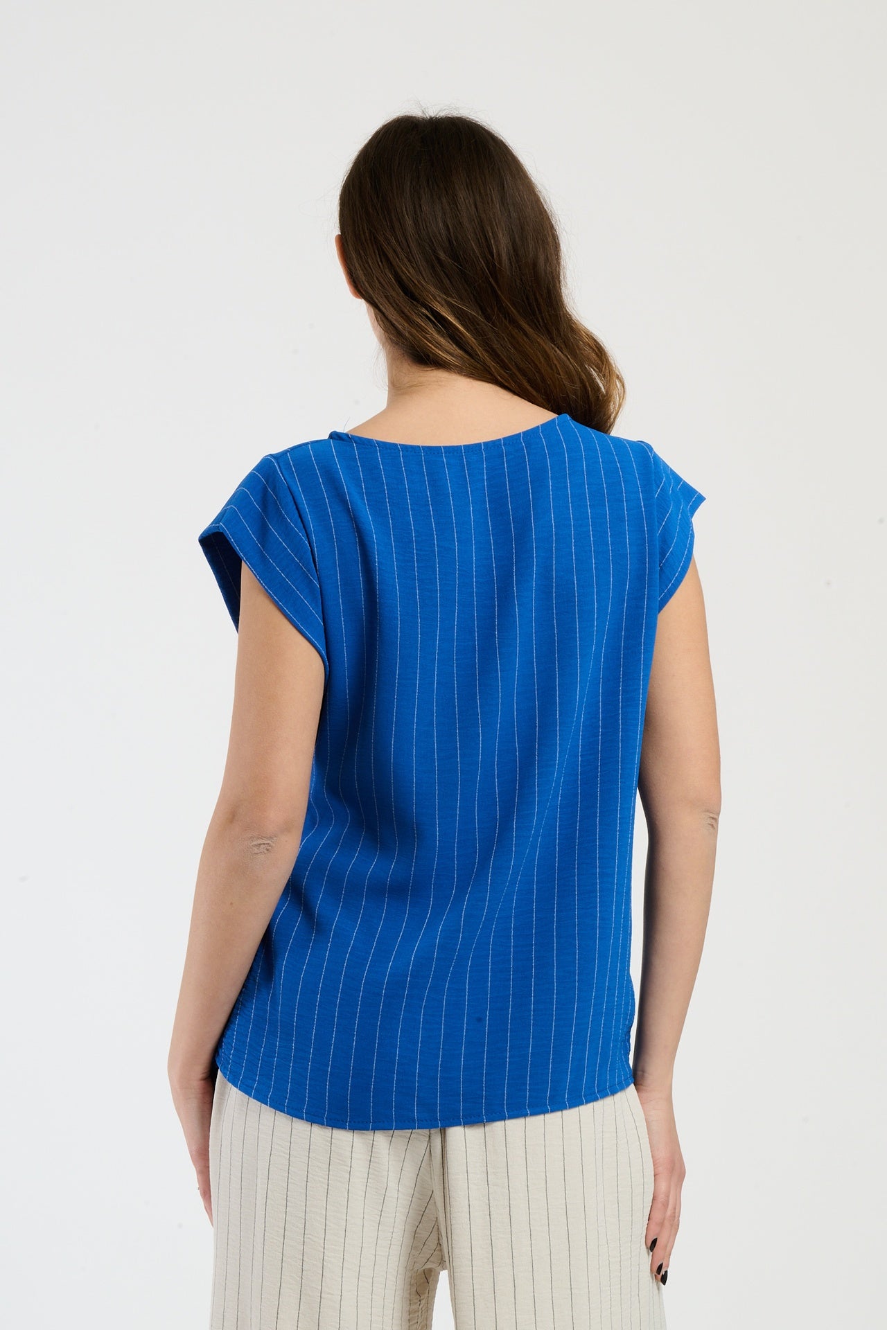 Donna in set bluette con top a nodo, combinazione elegante per ambienti casual.