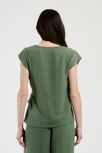 Donna in set militare con top a nodo, combinazione audace per uno stile unico.