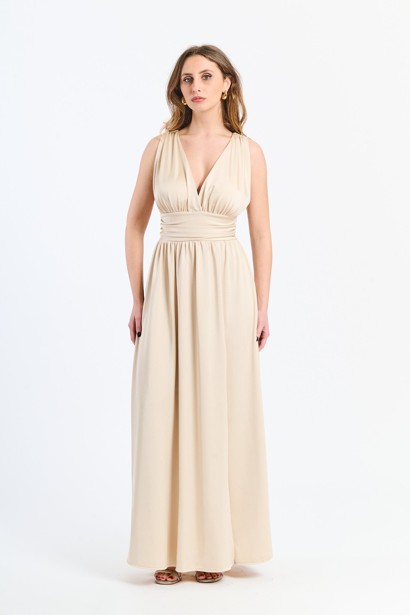 Lungo abito Beige senza maniche con scollo a V profondo e vita in pizzo, perfetto per uno stile classico ed elegante.