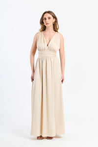 Lungo abito Beige senza maniche con scollo a V profondo e vita in pizzo, perfetto per uno stile classico ed elegante.