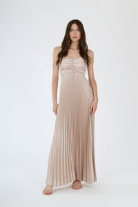 Lungo abito beige plissé con spalline sottili e busto ruched, perfetto per uno stile classico ed elegante.