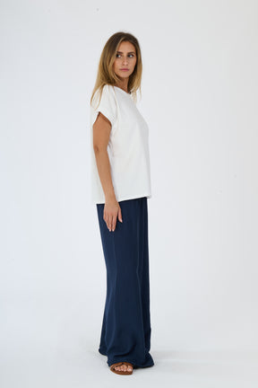 Moda casual beige: t-shirt e pantaloni ampi indossati da una donna elegante